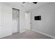 Bright bedroom features a built-in closet with drawers and shelving, carpeted floors, and a ceiling fan at 2612 Leafwing Ct, Palm Harbor, FL 34683
