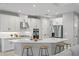 Modern kitchen featuring white cabinets, a large quartz island with seating, and stainless steel appliances at 2612 Leafwing Ct, Palm Harbor, FL 34683