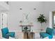 Bright living room featuring two teal chairs, tall ceilings, and a modern decor at 2612 Leafwing Ct, Palm Harbor, FL 34683