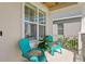 Inviting covered patio with two teal chairs and decorative plants at 2612 Leafwing Ct, Palm Harbor, FL 34683