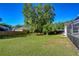 Expansive backyard featuring lush green grass, mature trees, and a screened-in patio at 2749 Bent Leaf Dr, Valrico, FL 33594