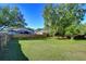 Spacious backyard featuring a well-maintained lawn, mature trees, and a wooden fence at 2749 Bent Leaf Dr, Valrico, FL 33594