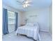 Cozy bedroom featuring a ceiling fan, large window, and comfortable bed with striped bedding at 2749 Bent Leaf Dr, Valrico, FL 33594