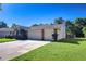 Spacious home with a three-car garage and well-manicured lawn, complemented by mature trees at 2749 Bent Leaf Dr, Valrico, FL 33594