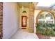 Inviting front entrance features a red door, arched window, brick accents, and decorative hanging light at 2749 Bent Leaf Dr, Valrico, FL 33594