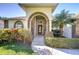 Inviting front entrance with an arched brick doorway, decorative glass door, and lush landscaping at 2749 Bent Leaf Dr, Valrico, FL 33594
