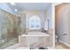 Bright main bathroom features a tiled shower, soaking tub, and a window, creating a spa-like atmosphere at 2749 Bent Leaf Dr, Valrico, FL 33594