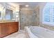 Stylish main bathroom features a walk-in shower, soaking tub, and dual sinks, perfect for relaxation at 2749 Bent Leaf Dr, Valrico, FL 33594