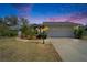 Charming single-story home with mature landscaping, two-car garage, and walkway under beautiful dusky sky at 2910 Pine Club Dr, Plant City, FL 33566