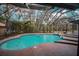 Large in-ground pool and hot tub with screened enclosure and brick paver decking at 2910 Pine Club Dr, Plant City, FL 33566
