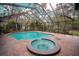 Relaxing pool area with hot tub, surrounded by a screened enclosure at 2910 Pine Club Dr, Plant City, FL 33566