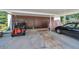 Covered carport providing parking and storage, featuring a golf cart and covered car at 3147 Mission Grove Dr # 3147, Palm Harbor, FL 34684