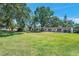 Expansive green lawn and manicured landscaping surrounding a building exterior with carports at 3147 Mission Grove Dr # 3147, Palm Harbor, FL 34684