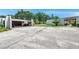 Exterior view showcasing the carport, paved driveway, and well-maintained landscaping at 3147 Mission Grove Dr # 3147, Palm Harbor, FL 34684