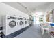Bright laundry room featuring multiple washers and dryers, seating, and bulletin board at 3147 Mission Grove Dr # 3147, Palm Harbor, FL 34684
