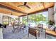 Light-filled sunroom with wood ceiling, comfortable seating, and views of the community pool at 3147 Mission Grove Dr # 3147, Palm Harbor, FL 34684