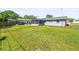 View of a home's backyard with a screen-enclosed porch and well-maintained lawn at 3210 Acacia St, Lutz, FL 33558