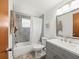 Updated bathroom featuring gray tile, modern fixtures, and a shower-tub combo at 3210 Acacia St, Lutz, FL 33558