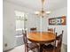 Dining area featuring wood table and chairs with view of screened-in patio through sliding glass doors at 3210 Acacia St, Lutz, FL 33558