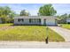 A well-maintained single-story home boasts a lush green lawn and a convenient attached garage at 3210 Acacia St, Lutz, FL 33558