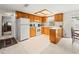 Functional kitchen with white appliances, wooden cabinets, and tiled flooring at 3210 Acacia St, Lutz, FL 33558
