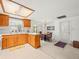 Bright kitchen with a breakfast bar, wooden cabinetry, and garden window above the sink at 3210 Acacia St, Lutz, FL 33558