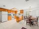 Bright kitchen with wooden cabinets, white appliances, and a cozy breakfast nook by the window at 3210 Acacia St, Lutz, FL 33558