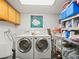 Functional laundry room with modern washer and dryer units, plus storage solutions at 3210 Acacia St, Lutz, FL 33558