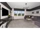 Modern living room with gray sofa, stylish lighting, and media console with decorative accents near bright windows at 33317 Barnebrook Dr, Wesley Chapel, FL 33545