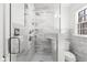 White marble shower with dual shower heads, built-in shelving, and a glass door at 346 16Th Ne Ave, St Petersburg, FL 33704