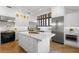 Open kitchen with marble island, stainless steel appliances and view into the living room at 346 16Th Ne Ave, St Petersburg, FL 33704