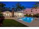 Inviting pool at twilight next to a covered patio, brick fireplace, and lush greenery at 346 16Th Ne Ave, St Petersburg, FL 33704