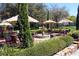 Beautiful outdoor seating area featuring a decorative fountain, lush greenery, and umbrella-covered tables at 36750 Us 19 N # 19212, Palm Harbor, FL 34684