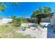 Landscaped backyard featuring mature trees, gravel, plants, and covered pavilion, creating a relaxing outdoor space at 412 River S Blvd, Nokomis, FL 34275
