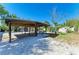 Wide backyard featuring gravel, patio, and a wooden pavilion with seating, perfect for entertaining at 412 River S Blvd, Nokomis, FL 34275