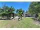 Spacious backyard featuring manicured lawn, gravel, plants, and a wooden pavilion, perfect for outdoor living at 412 River S Blvd, Nokomis, FL 34275