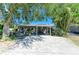 Front exterior featuring a well-kept home with a covered carport, landscaped yard and mature shade trees at 412 River S Blvd, Nokomis, FL 34275