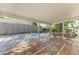 A beautiful covered patio with decorative tile flooring offers a view of the landscaped yard at 412 River S Blvd, Nokomis, FL 34275