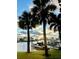 Scenic waterfront view of boats docked along a serene waterfront, framed by palm trees at 430 Larboard Way # 3, Clearwater Beach, FL 33767