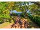 Aerial view of the backyard and waterfront, showing the patio, fire pit, dock, and lush greenery at 4605 W Vasconia St, Tampa, FL 33629