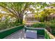 A beautiful backyard featuring a wooden deck, lush landscaping, and a view of the home's rear elevation at 4605 W Vasconia St, Tampa, FL 33629