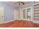 Spacious bedroom featuring hardwood floors, custom shelving, and glass paneled french doors at 4605 W Vasconia St, Tampa, FL 33629