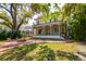 View of the house showing the brick patio, fire pit, and mature trees in the landscaped yard at 4605 W Vasconia St, Tampa, FL 33629