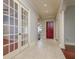 Hallway with french doors, travertine floors, and a red front door at 4605 W Vasconia St, Tampa, FL 33629