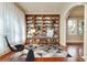 Bright home office featuring custom wood built-ins, modern decor, and a large window with sheer curtains at 4605 W Vasconia St, Tampa, FL 33629