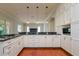 Open kitchen featuring granite counters, white cabinetry, stainless appliances, and pendant lights at 4605 W Vasconia St, Tampa, FL 33629