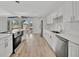 Open concept kitchen with white cabinetry, stainless appliances, and hardwood floors at 4720 50Th N Ave, St Petersburg, FL 33714