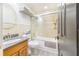 Well-lit bathroom featuring a shower-tub combo, tiled walls, and a modern sink at 506 S Willow Ave # 7, Tampa, FL 33606