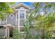 Charming two-story home with gray siding, white trim, and a well-manicured front yard, framed by lush trees and flowering plants at 506 S Willow Ave # 7, Tampa, FL 33606