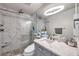 Beautiful bathroom features glass shower doors, stone floors, vanity, and updated lighting at 5101 Coquina Key Se Dr # A, St Petersburg, FL 33705